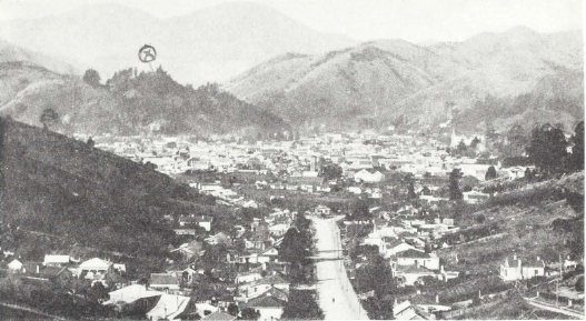 Marked spot on hilltop indicates center of New Zealand, where the sand from the Holy Land was placed by Bahá’ís. The city of Nelson in the valley below.